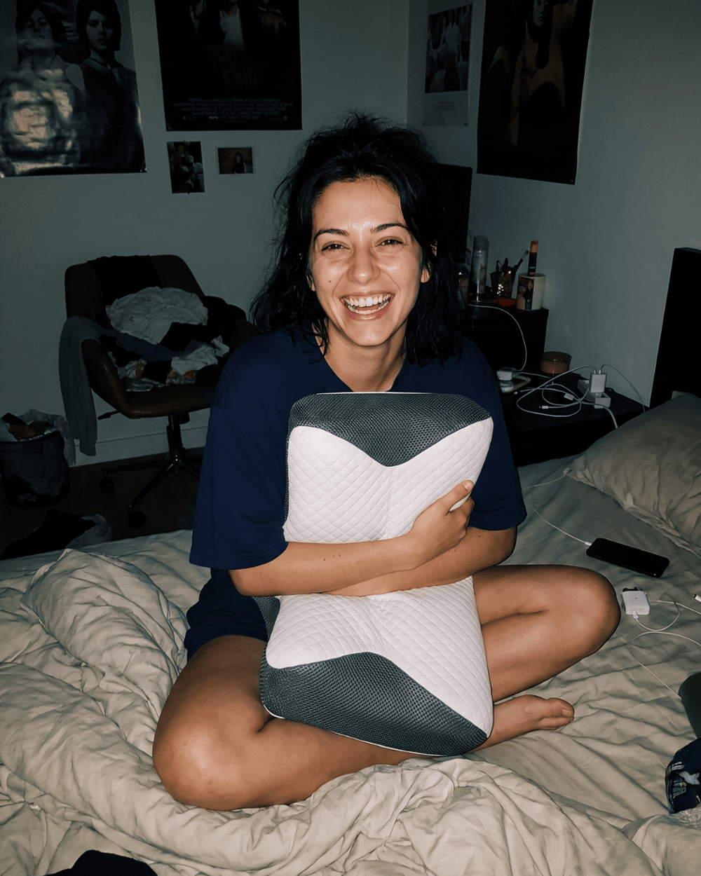 Vrouw zit op bed met het CLSN nekkussen in haar armen